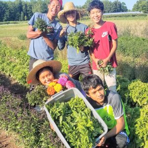 youth with produce at 5 loaves farm