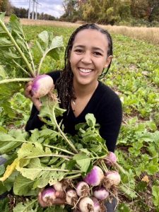 Beauty Bloom’s Founder and Farm Manager Nia Nyamweya shows off a turnip she grew.