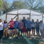 Group in front of hoop house