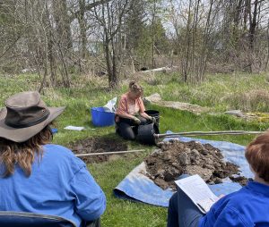 Farm demonstrating preparing tree for planting 